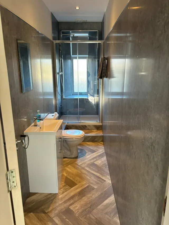 Modern bathroom with walk-in shower and herringbone floor