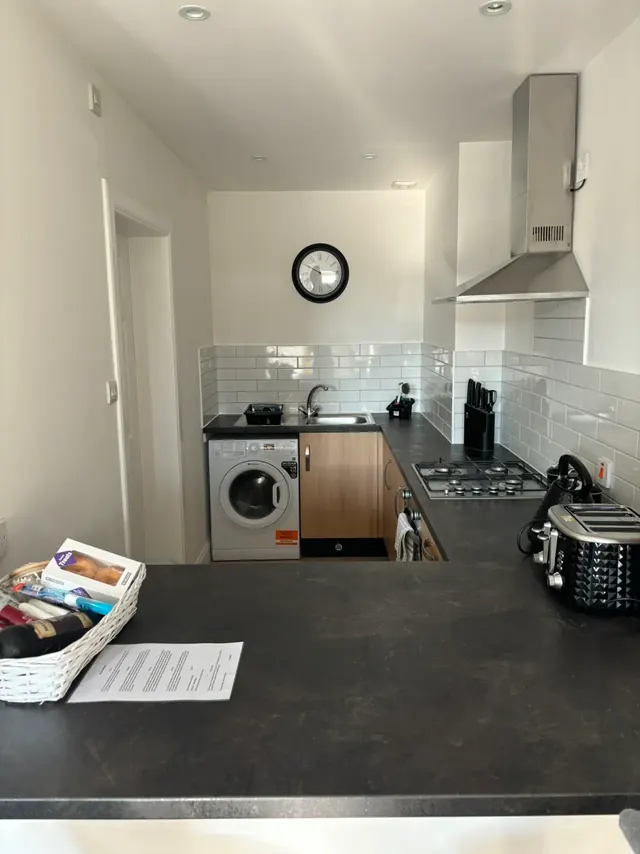Modern kitchen with gas hob, washing machine and breakfast bar
